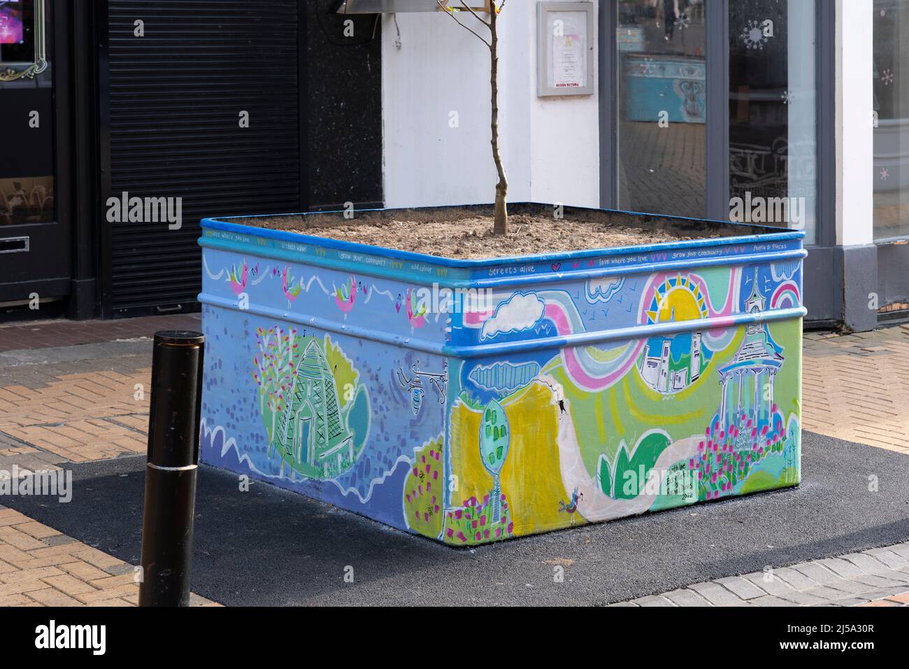 Hand painted mural of local Basingstoke scenes on a planter in Basingstoke town centre April 2022. Part of Streets Alive celebrating local artists. UK Stock Photo