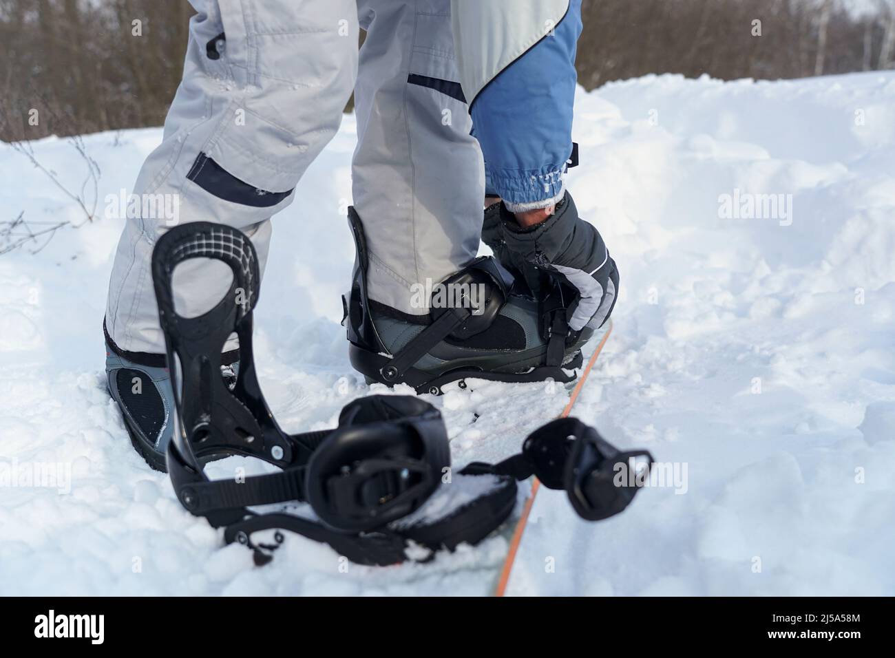 The guy fastens the binding on the snowboard Stock Photo