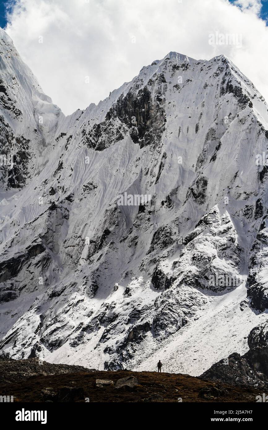 A lone sherpa stands before Ama Dablam mountain - Nepal Stock Photo