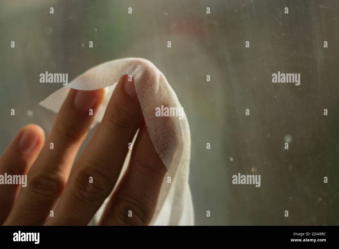 Wiping window from dirt. Cleaning of room. Erasing dust with damp cloth