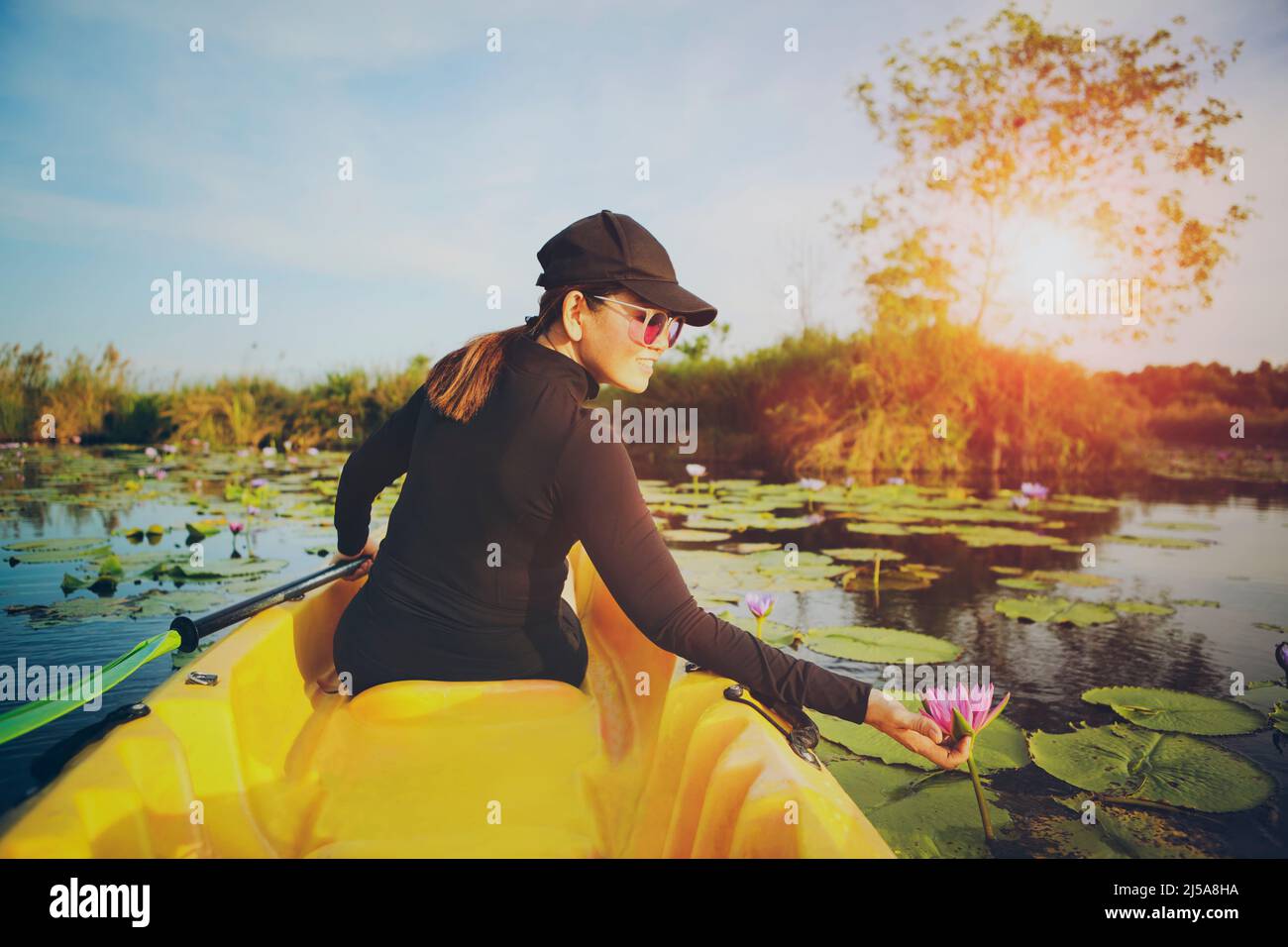 woman sailing sea kayak in lotus flower lagoon Stock Photo