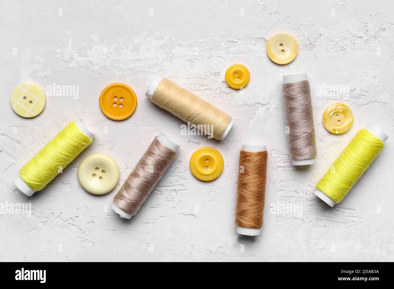 Sewing threads and buttons on light background Stock Photo - Alamy