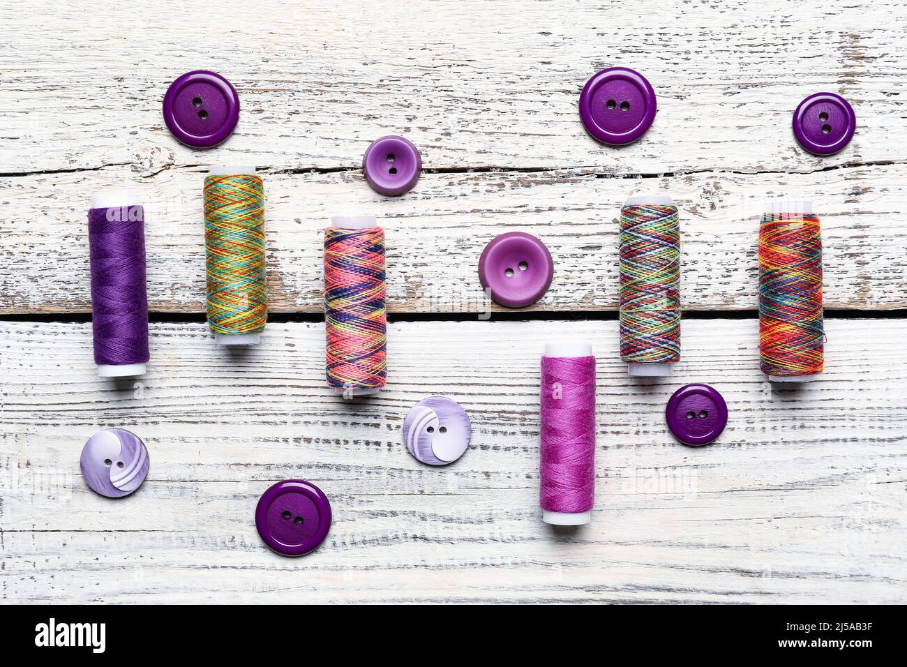 Sewing threads and buttons on light wooden background Stock Photo - Alamy