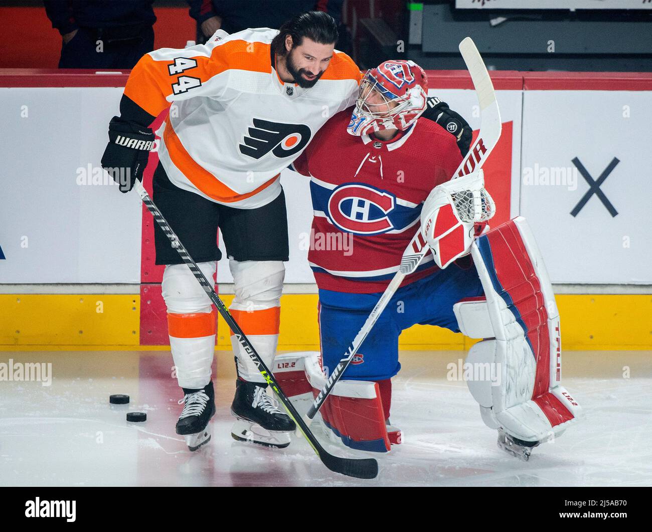 Montreal Canadiens goaltender Carey Price, right, is hugged by former teammate and Philadelphia Flyers player Nate Thompson prior to NHL hockey action in Montreal, Thursday, April 21, 2022