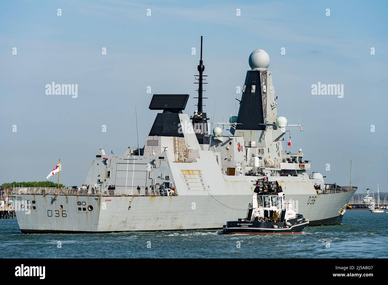 HMS Defender (D36) returned to Portsmouth, UK on the 19th April 2022. Seen with the escorting tug SD Independent alongside. Stock Photo