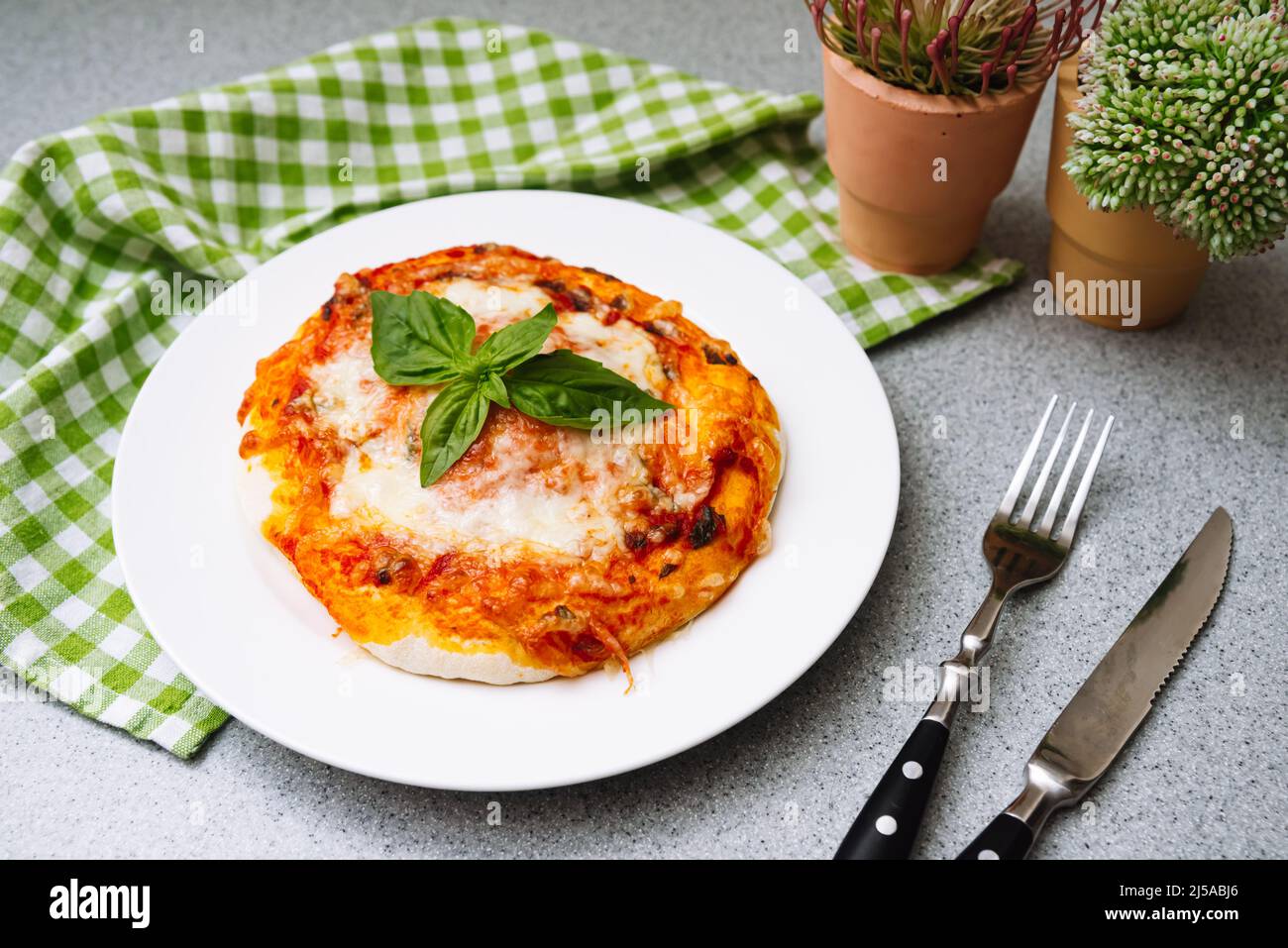 Homemade Margherita pizza with cheese, tomato sauce and basil leaf with crispy crust. Stock Photo