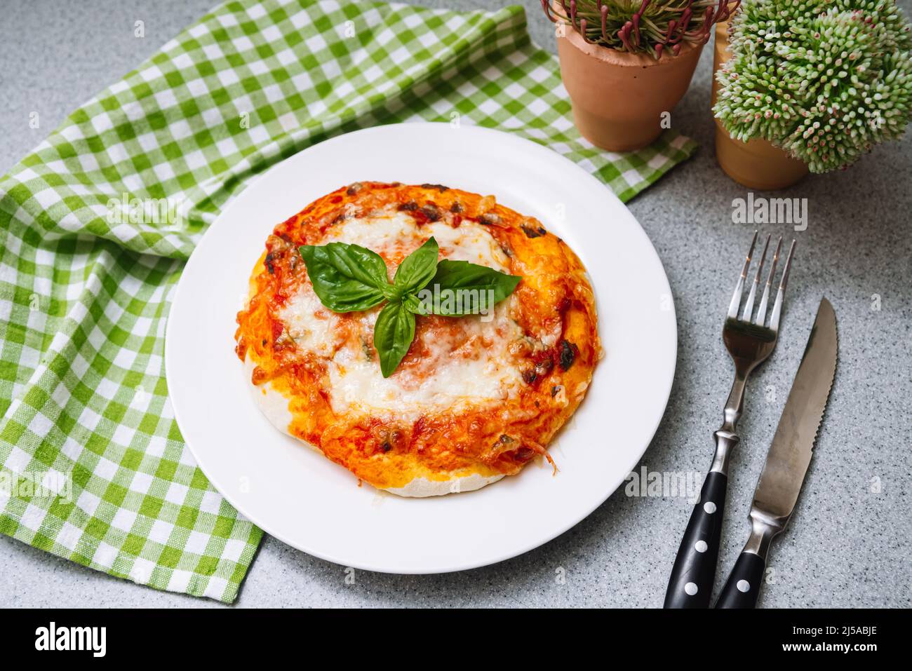 Homemade Margherita pizza with cheese, tomato sauce and basil leaf with crispy crust. Stock Photo