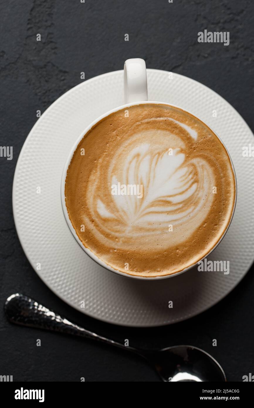White cup of hot latte coffee with beautiful milk foam latte art
