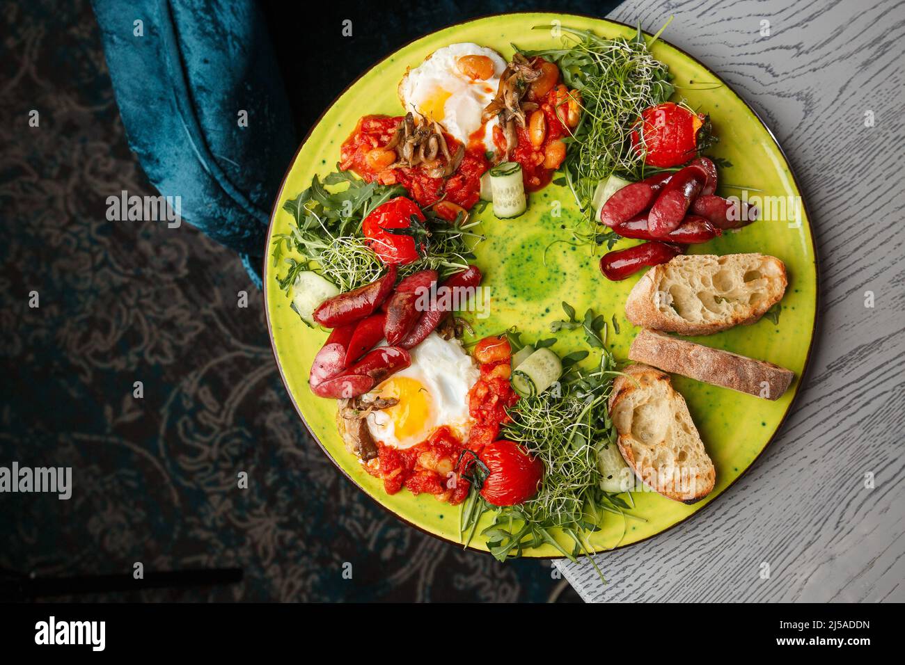 Eggs with vegetable, sausages, tomatoes, red beans and sourdough toast isolated on grey wooden background. Homemade food. Tasty breakfast. Selective f Stock Photo