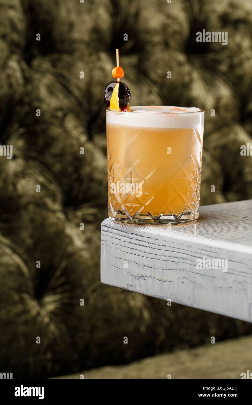 Pisco sour cocktail whiskey with lime, egg white, sugar syrup in glass on dark background