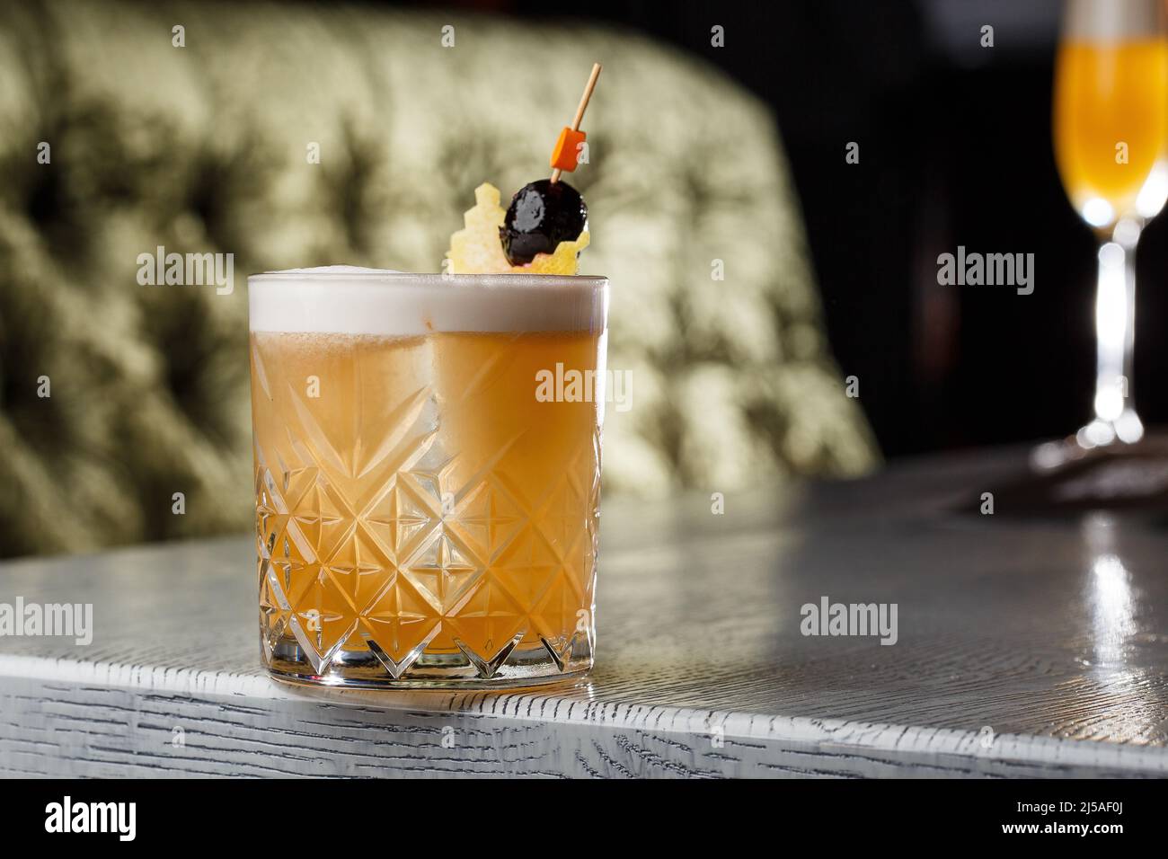 Pisco sour cocktail whiskey with lime, egg white, sugar syrup in glass on dark background