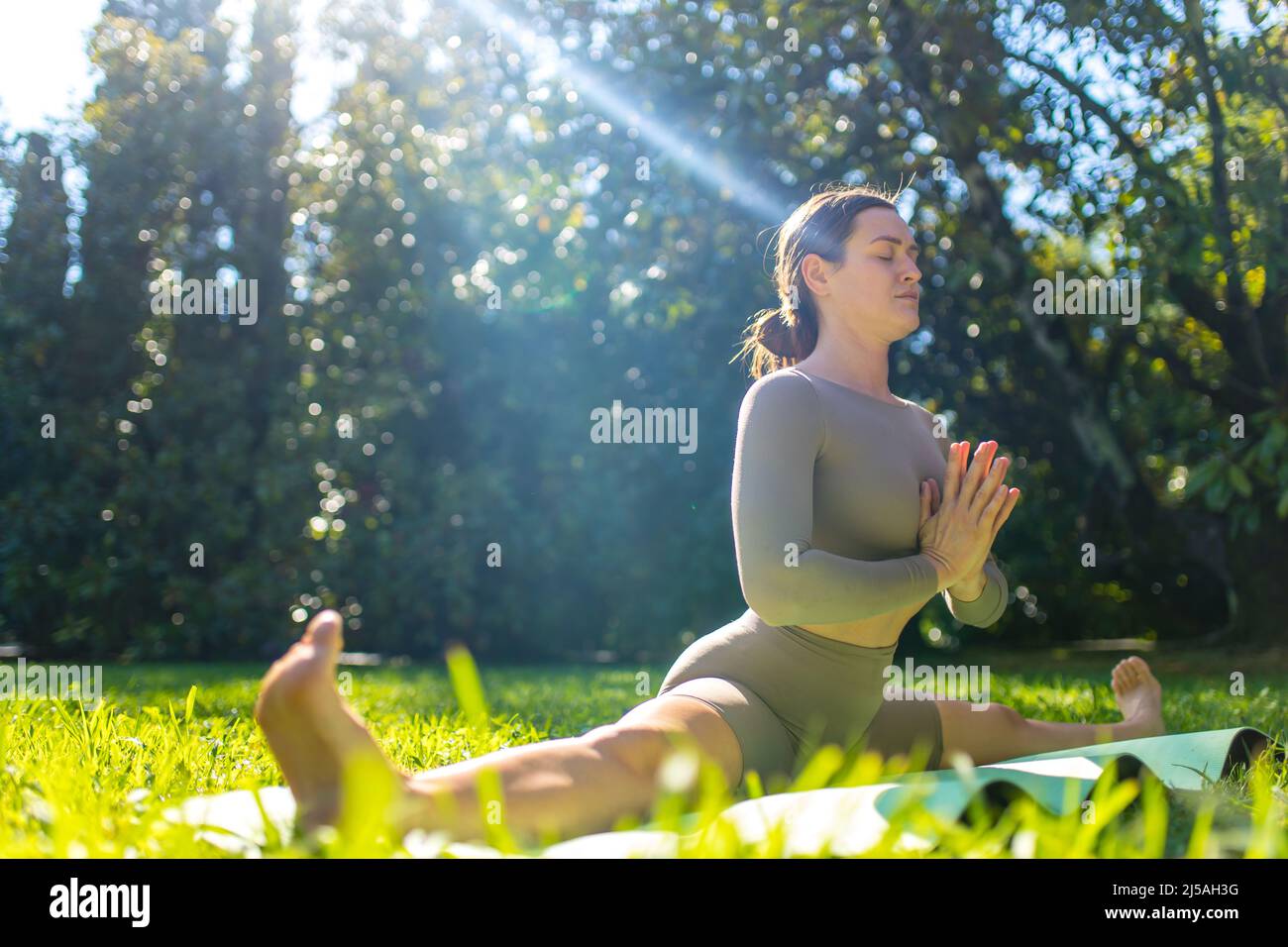 woman doing acro yoga exercises in the morning in tropical park Stock Photo