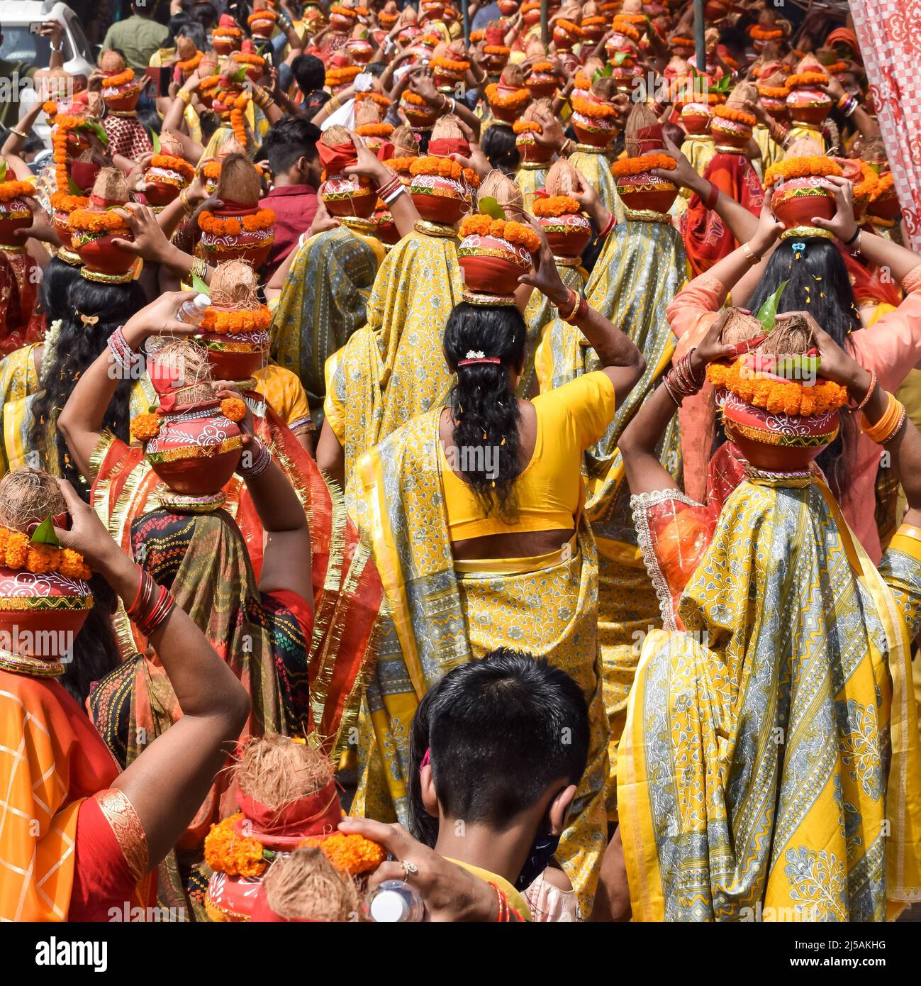 Women with Kalash on head during Jagannath Temple Mangal Kalash Yatra, Indian Hindu devotees carry earthen pots containing sacred water with a coconut Stock Photo