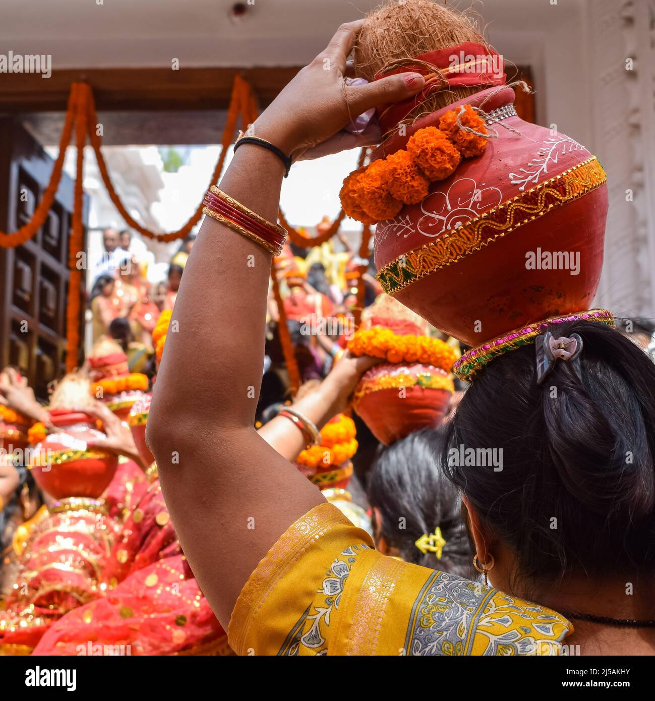 Women with Kalash on head during Jagannath Temple Mangal Kalash Yatra, Indian Hindu devotees carry earthen pots containing sacred water with a coconut Stock Photo