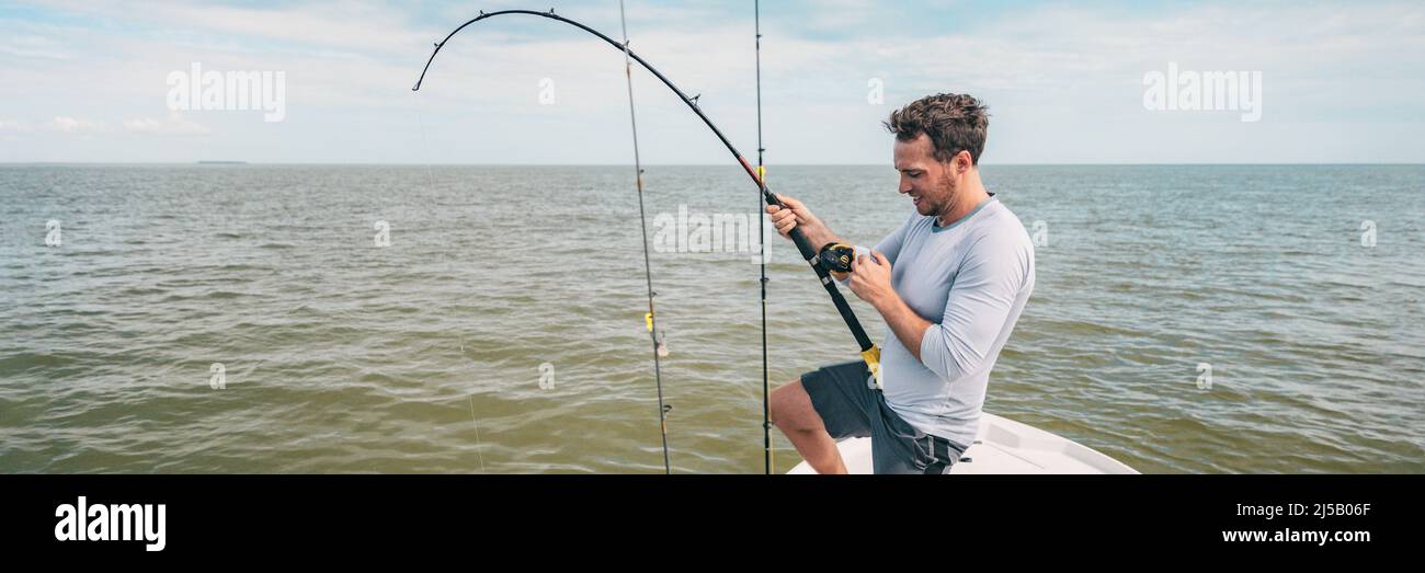 Fishing young man with sport fish rod and reel line for recreation on summer ocean day. Recreational fishing fisherman outdoor leisure lifestyle Stock Photo