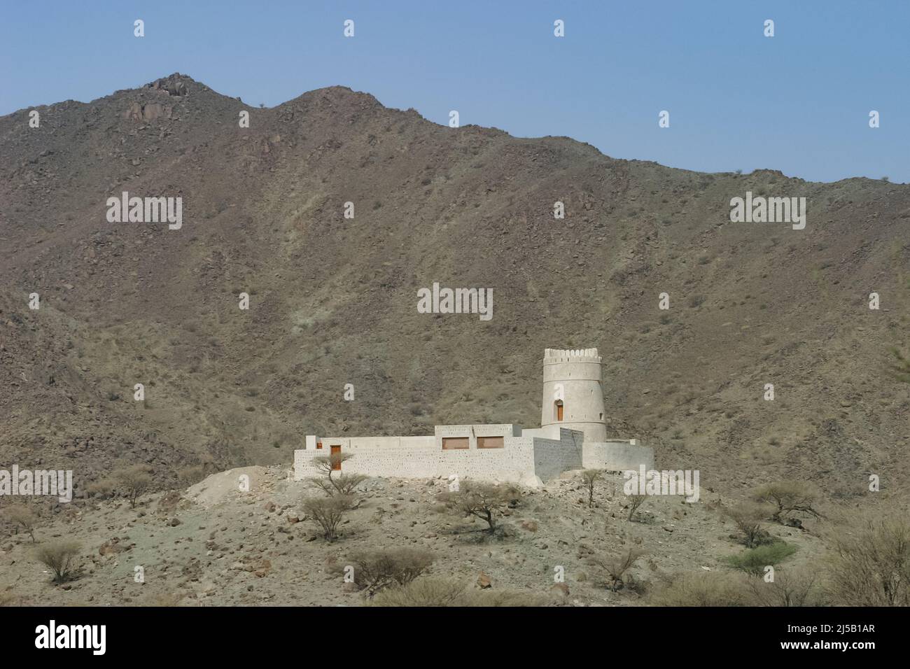 A solitary hilltop fort in the interior of the east coast of the Emirate of Sharjah in the United Arab Emirates. Stock Photo