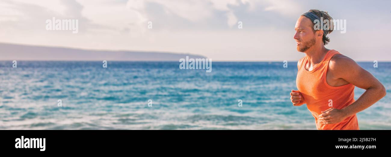 Athlete man runner sweating tired during endurance workout on beach running at sunset portrait panoramic banner. Active lifestyle Stock Photo