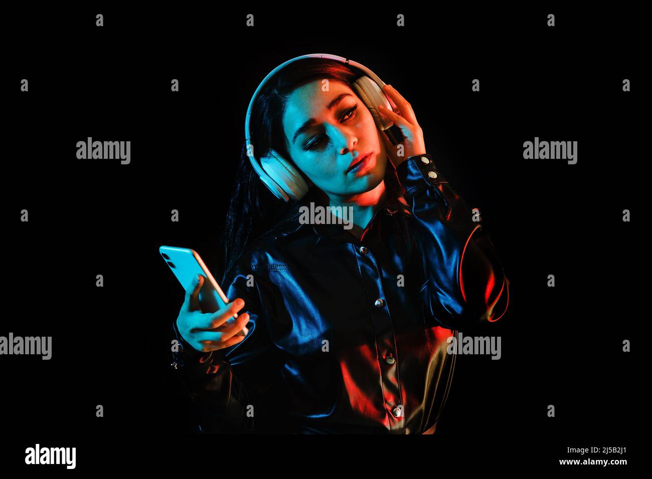 latin young woman with headphones listening to music over color neon