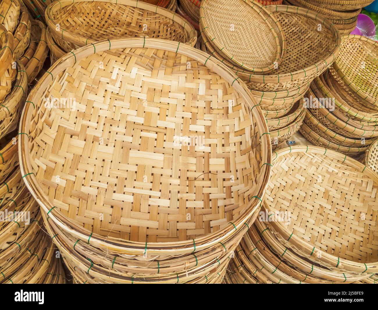 Variety of circular woven cane baskets for sale at street market Stock