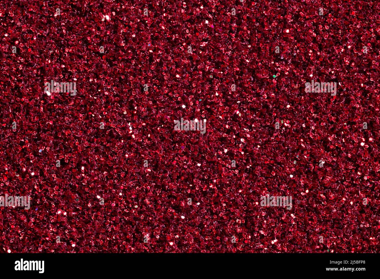 Dark wine coloured background with glitter close-up. Stock Photo