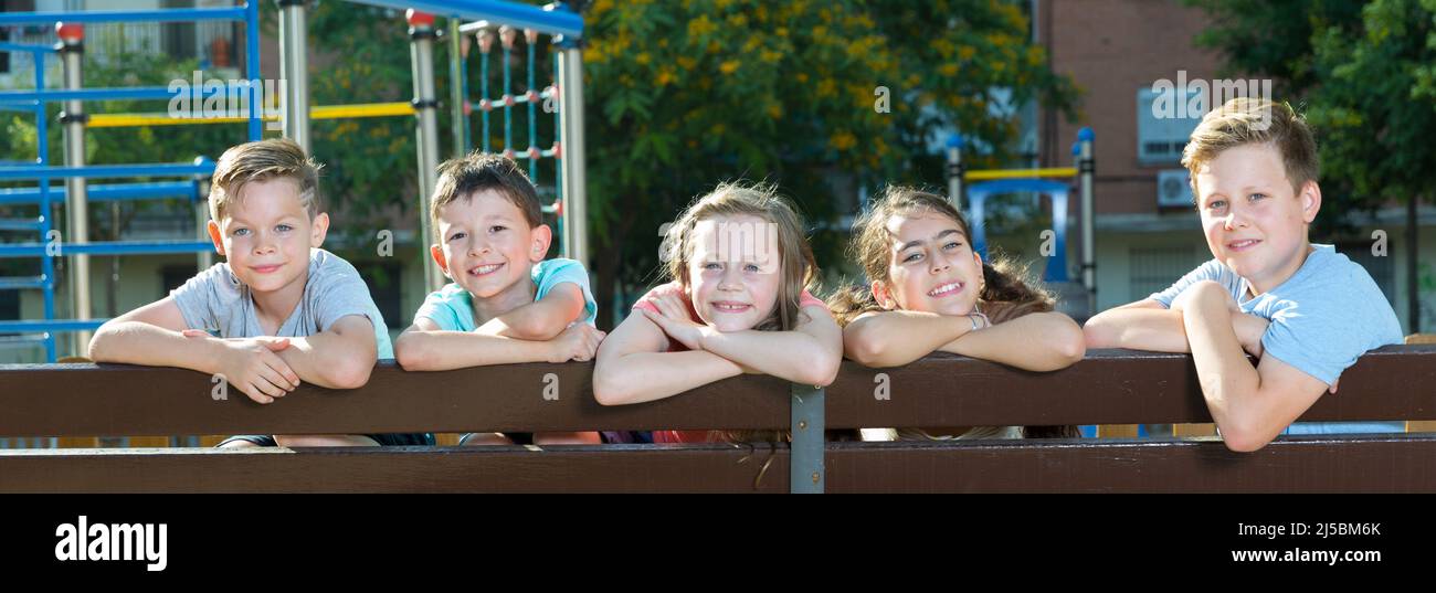 Five glad children sitting on a bench Stock Photo - Alamy