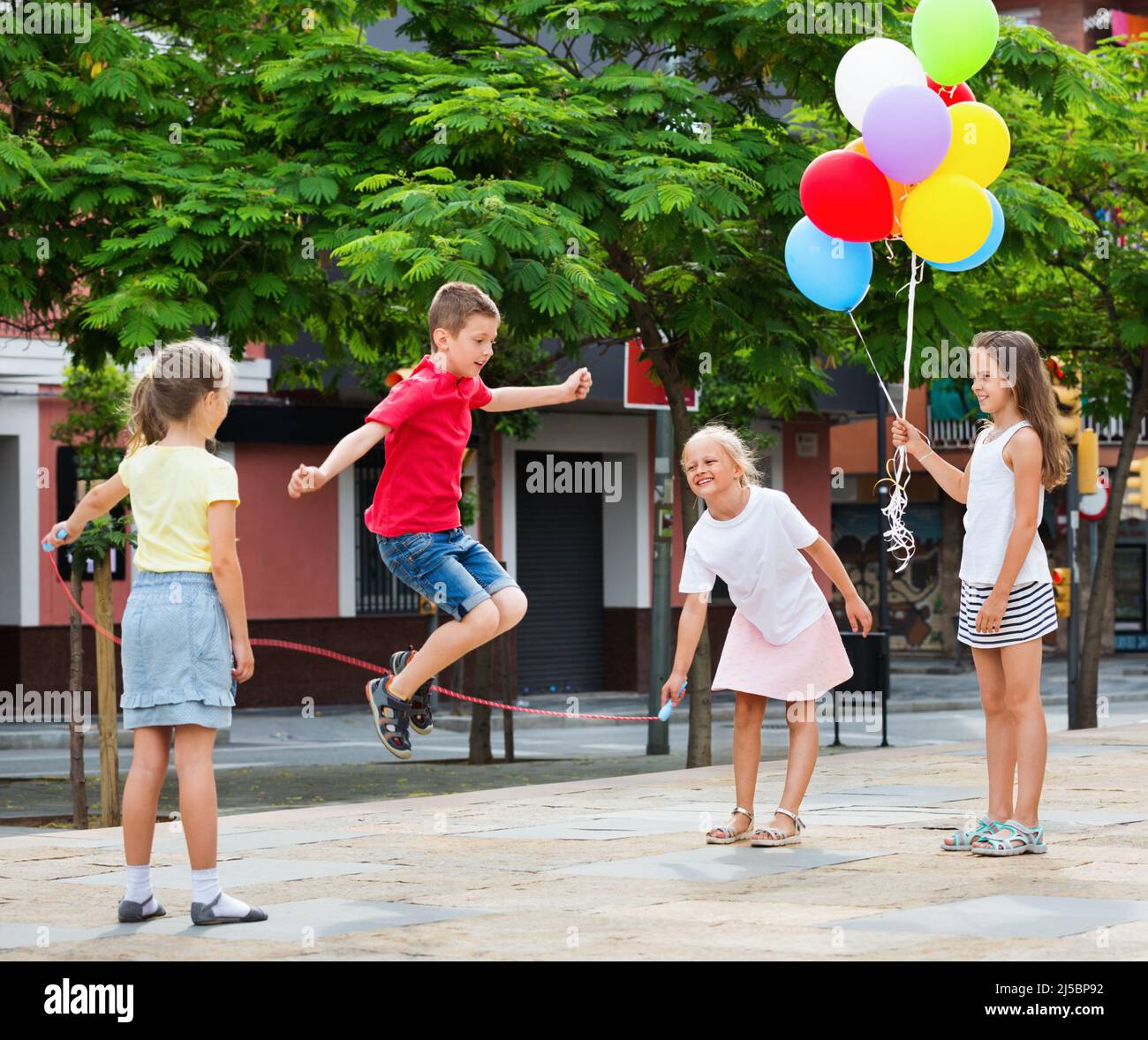Kids in school age playing together with jumping rope Stock Photo Alamy
