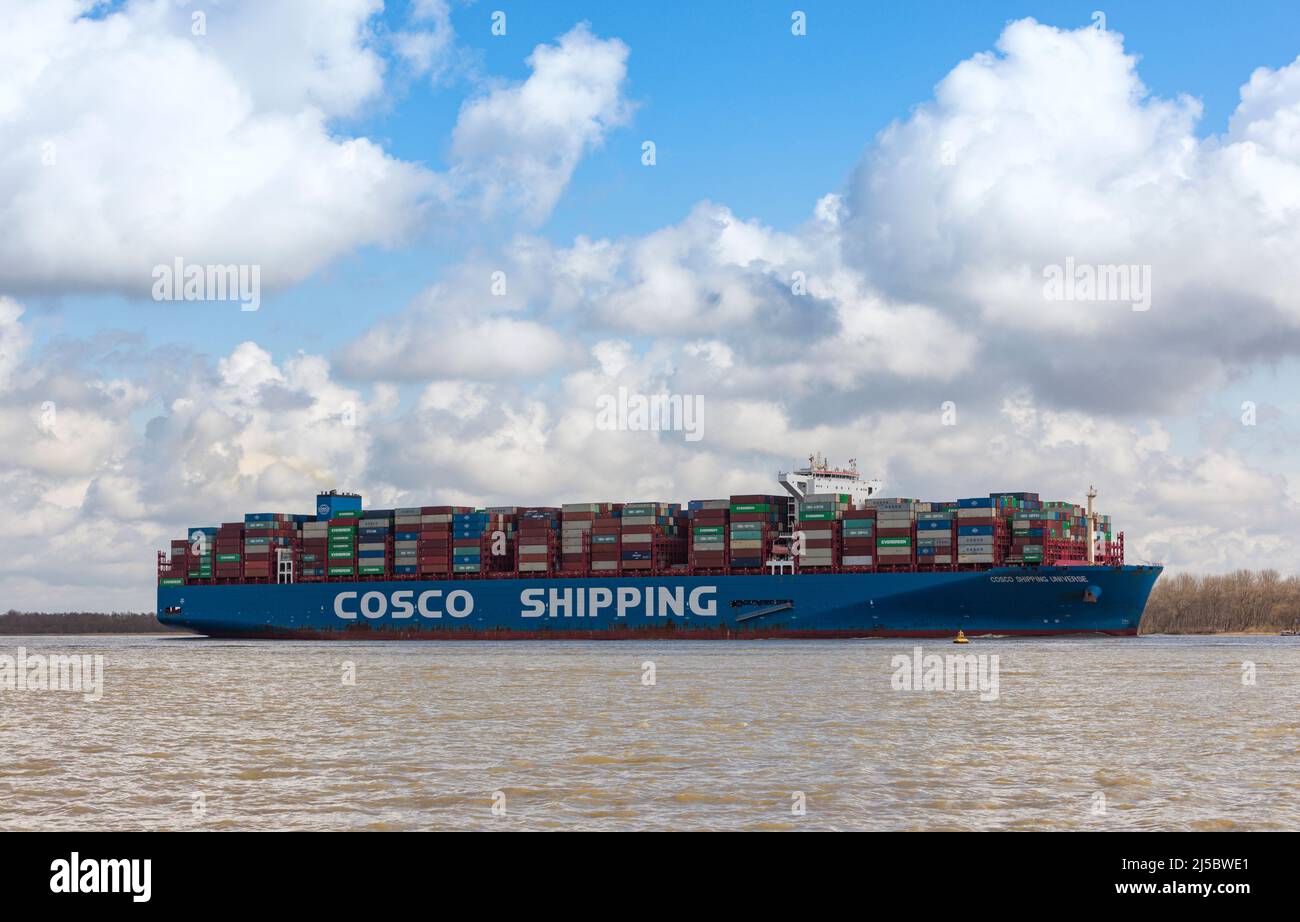 Container ship COSCO SHIPING UNIVERSE on Elbe river heading to Hamburg Stock Photo