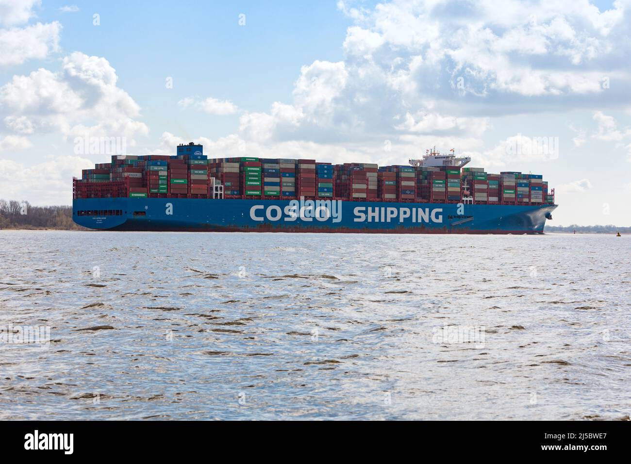 Container ship COSCO SHIPING UNIVERSE on Elbe river heading to Hamburg Stock Photo