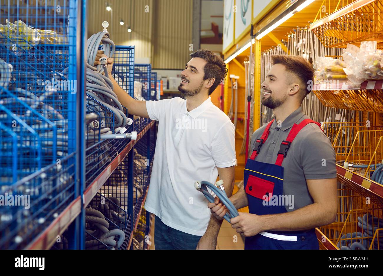 Sales assistant at hardware store helping customer choose new hose for