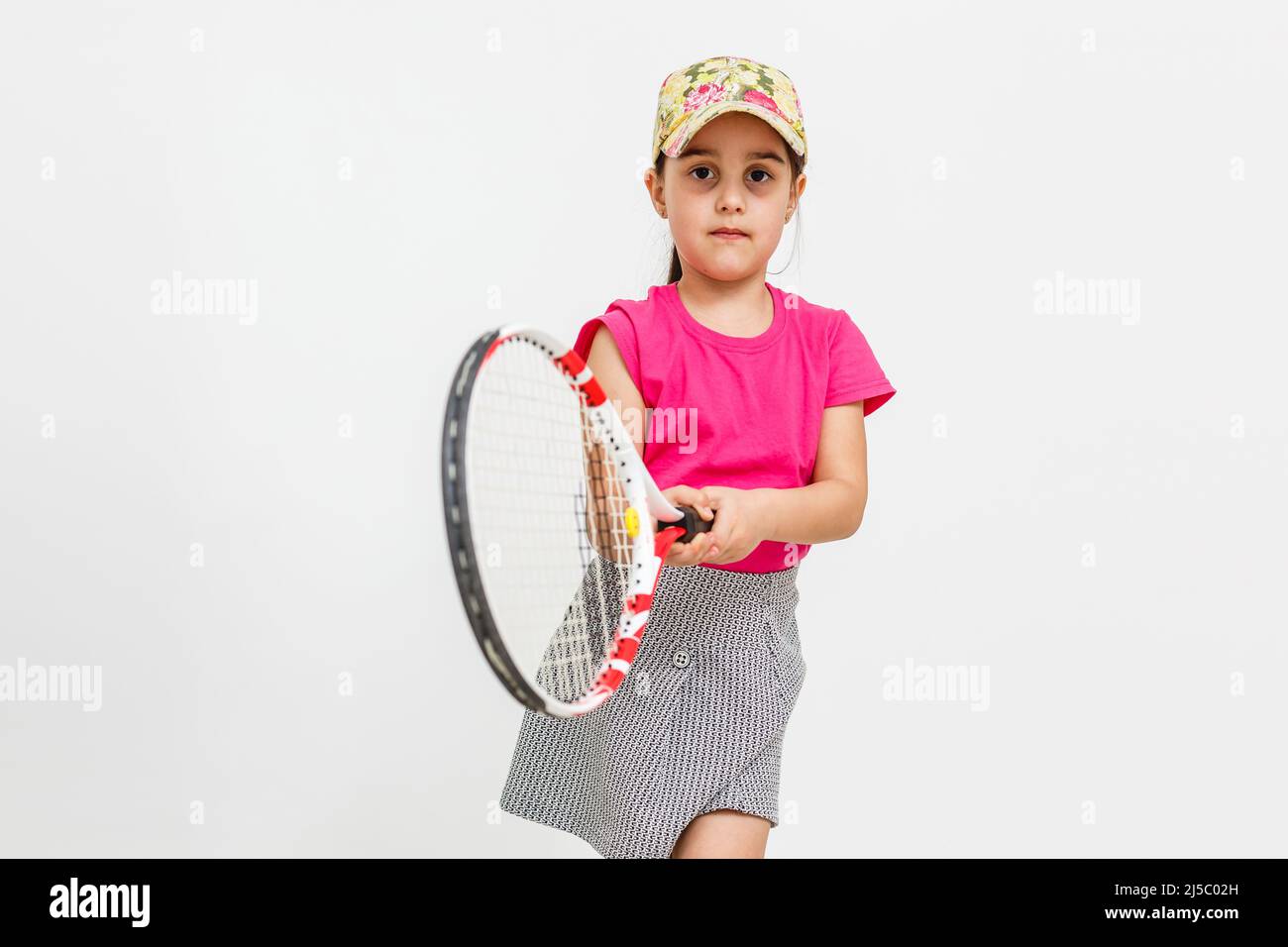 Little Tennis Rackets Cute little girl with tennis racket on white background Stock Photo - Alamy