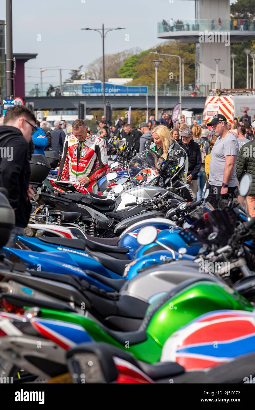 Southend Shakedown 2022 motorcycle gathering in Southend on Sea, Essex, UK. Colourful row of motorbikes with female and male bikers viewing. Busy Stock Photo