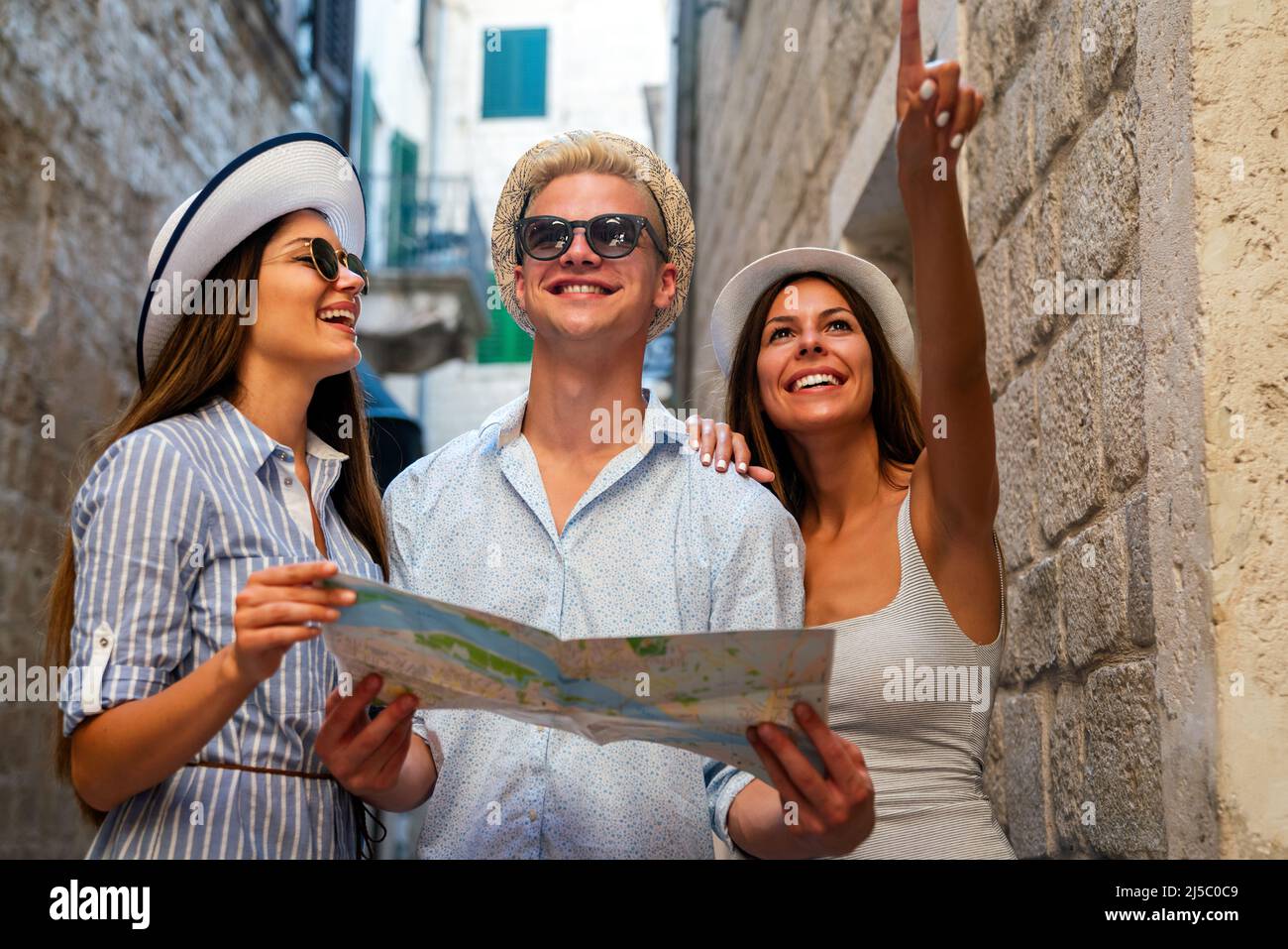 Happy group of young friends enjoying sightseeing tour in the city on ...