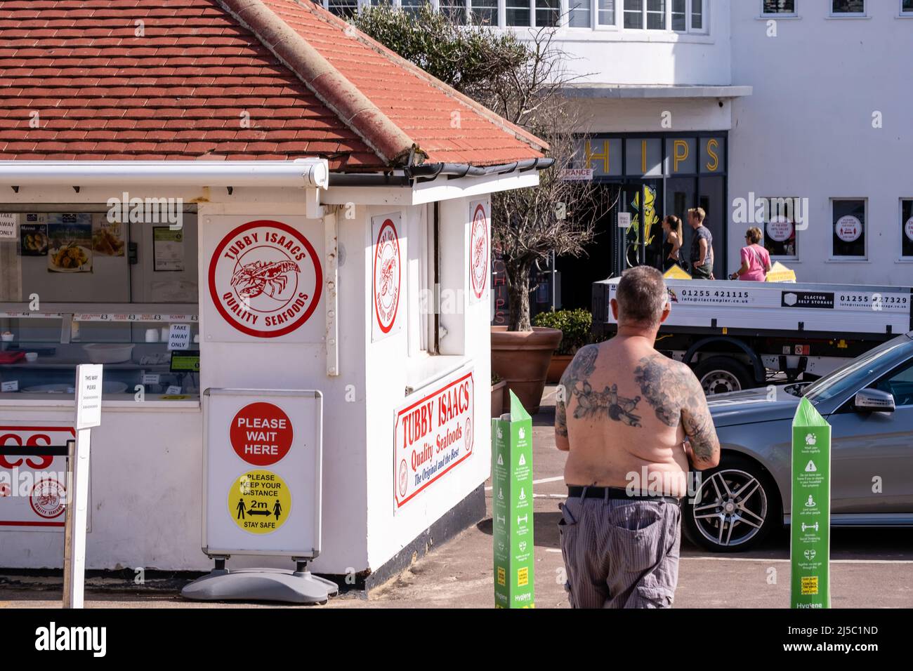 Man with tattoos outside Tubby Isaacs seafood stall in Clacton-on-Sea in Essex. Stock Photo