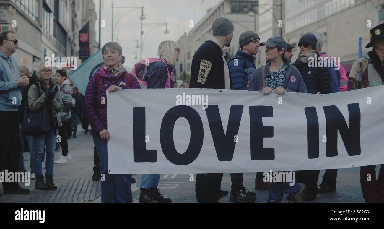 London, UK - 04 09 2022:  Extinction Rebellion climate protesters blocking Oxford Street, holding a banner, ‘Love In Action’. Stock Photo