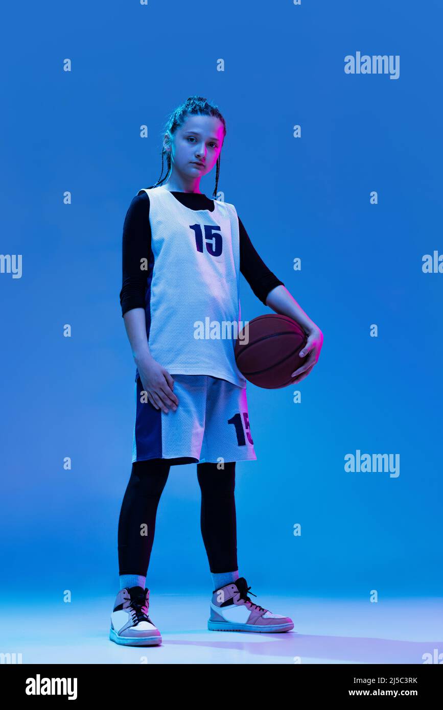 Portrait of teen girl, basketball player in uniform posing isolated