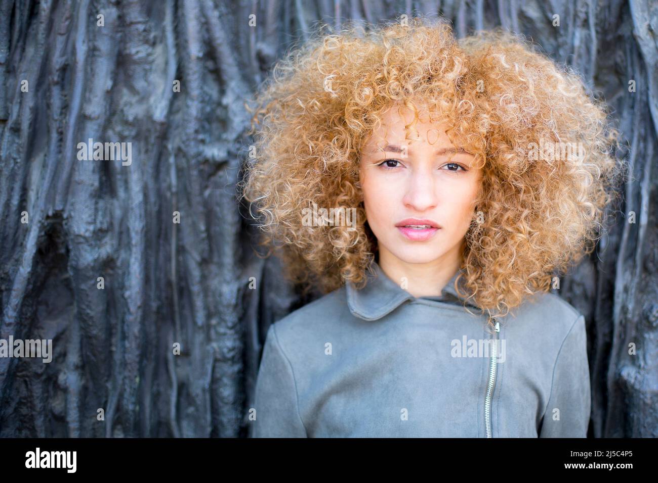 closeup young latin woman with curly afro hair outdoors with soft light Stock Photo