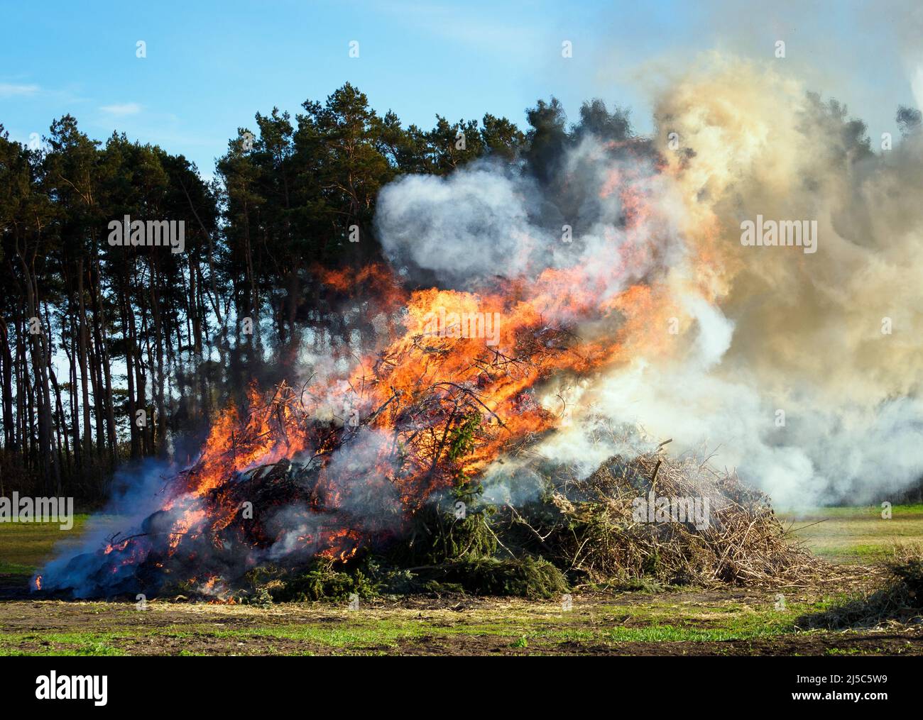 Kathendorf, Germany. 16th Apr, 2022. An Easter fire burns near a pine forest in the early evening. Credit: Soeren Stache/dpa/Alamy Live News Stock Photo