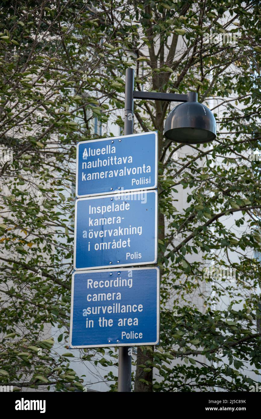 Signs in Swedish, Finnish, and English warning of surveillance cameras in Telakkapuistikko, Helsinki, Finland. Stock Photo