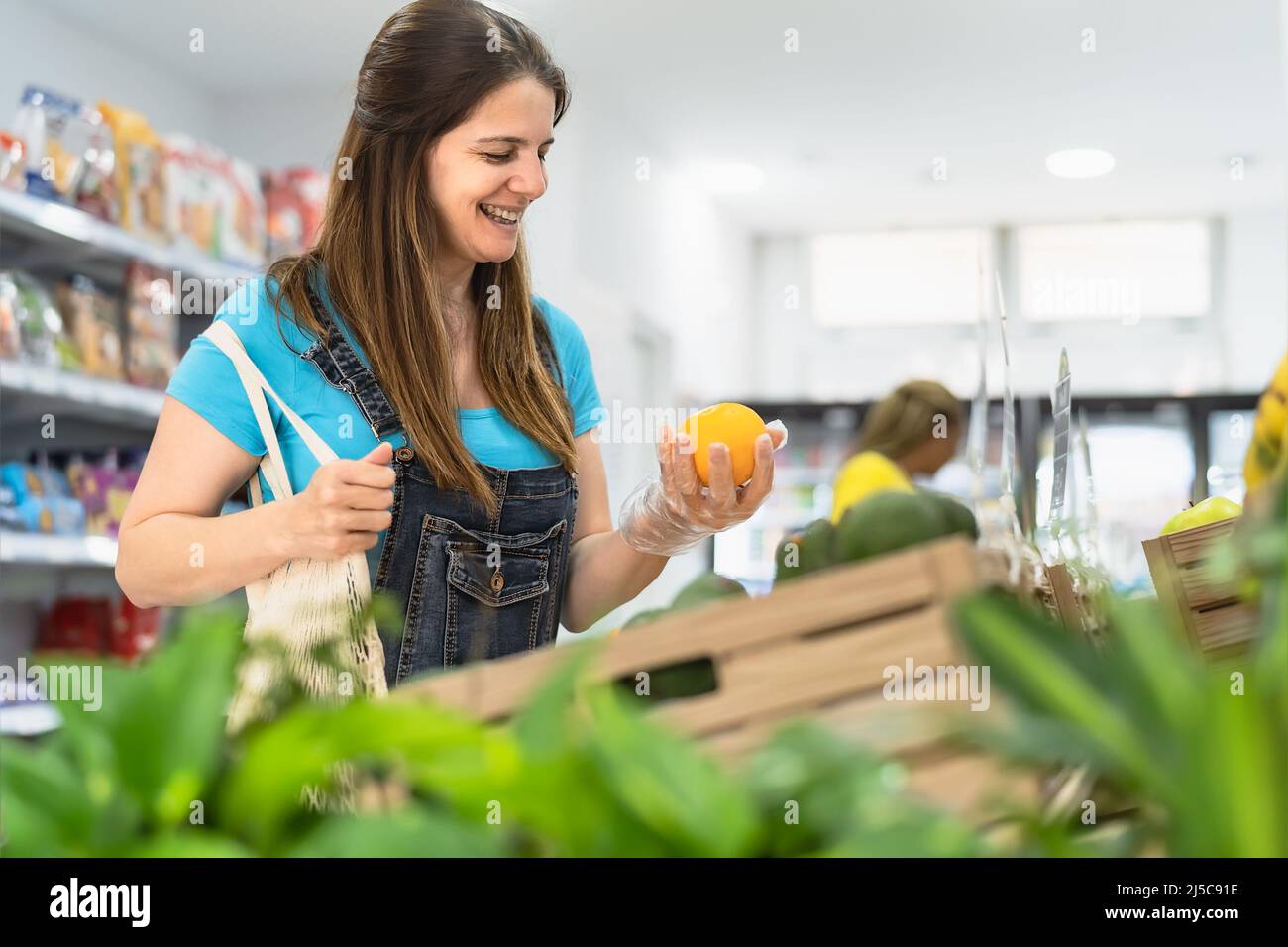 Female customer buying organic fresh fruits inside supermarket Stock Photo