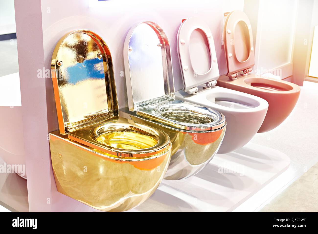 Golden, silver and plastic flush toilet in the store Stock Photo