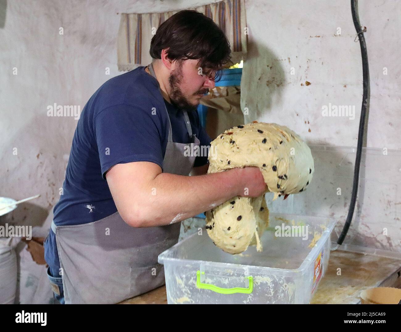 Non Exclusive: BUCHA, UKRAINE - APRIL 21, 2022 - Owner of the Khatynka pekaria (Baker's Hut) craft bakery Yaroslav Burkivskyi kneads dough for Easter Stock Photo