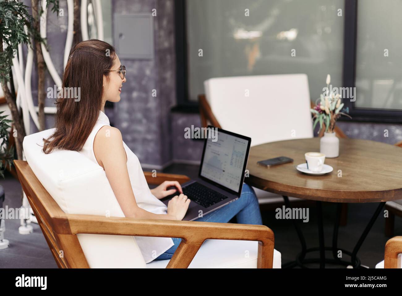 smiling young woman browsing through email on her laptop Stock Photo ...
