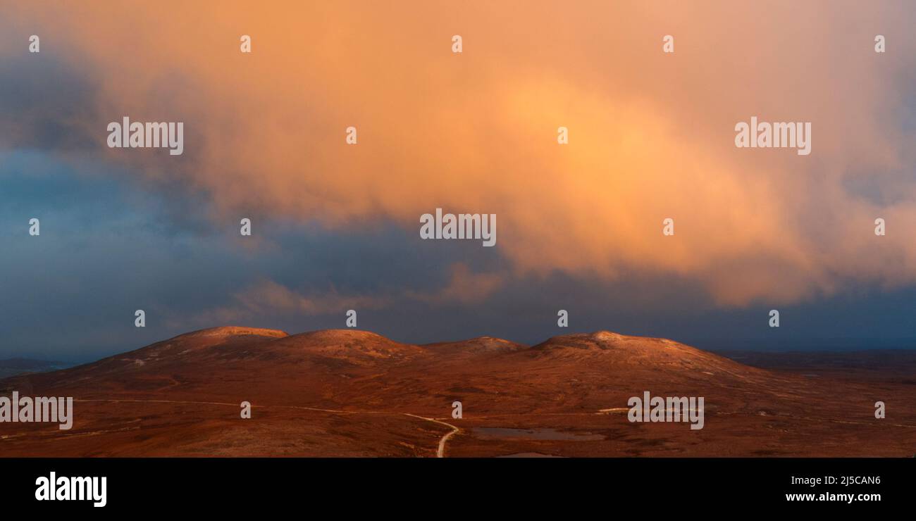 Sunlit clouds at sunrise over Scottish mountain Stock Photo