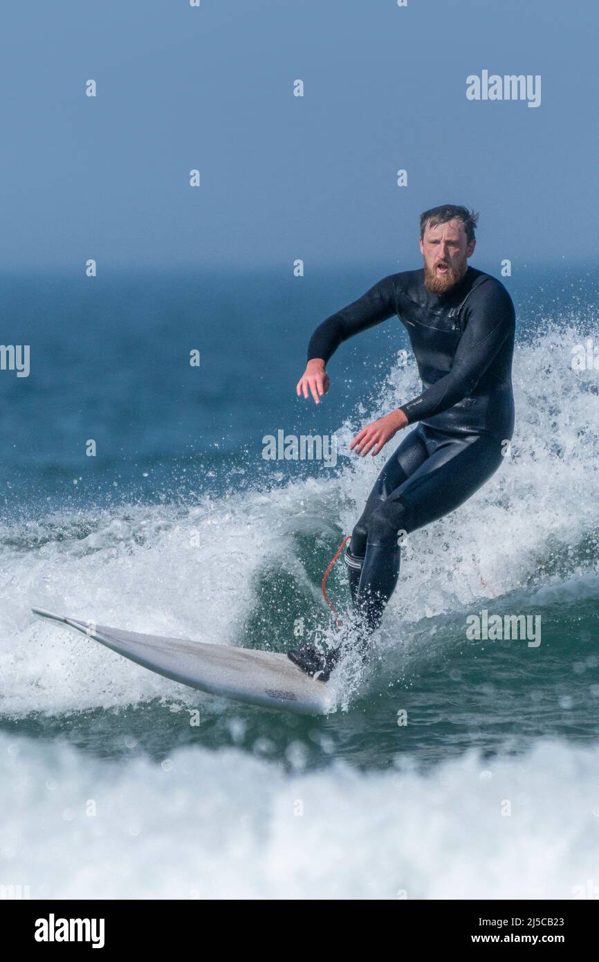 A male surfer riding a wave at Fistral in Newquay in Cornwall in the UK. Stock Photo