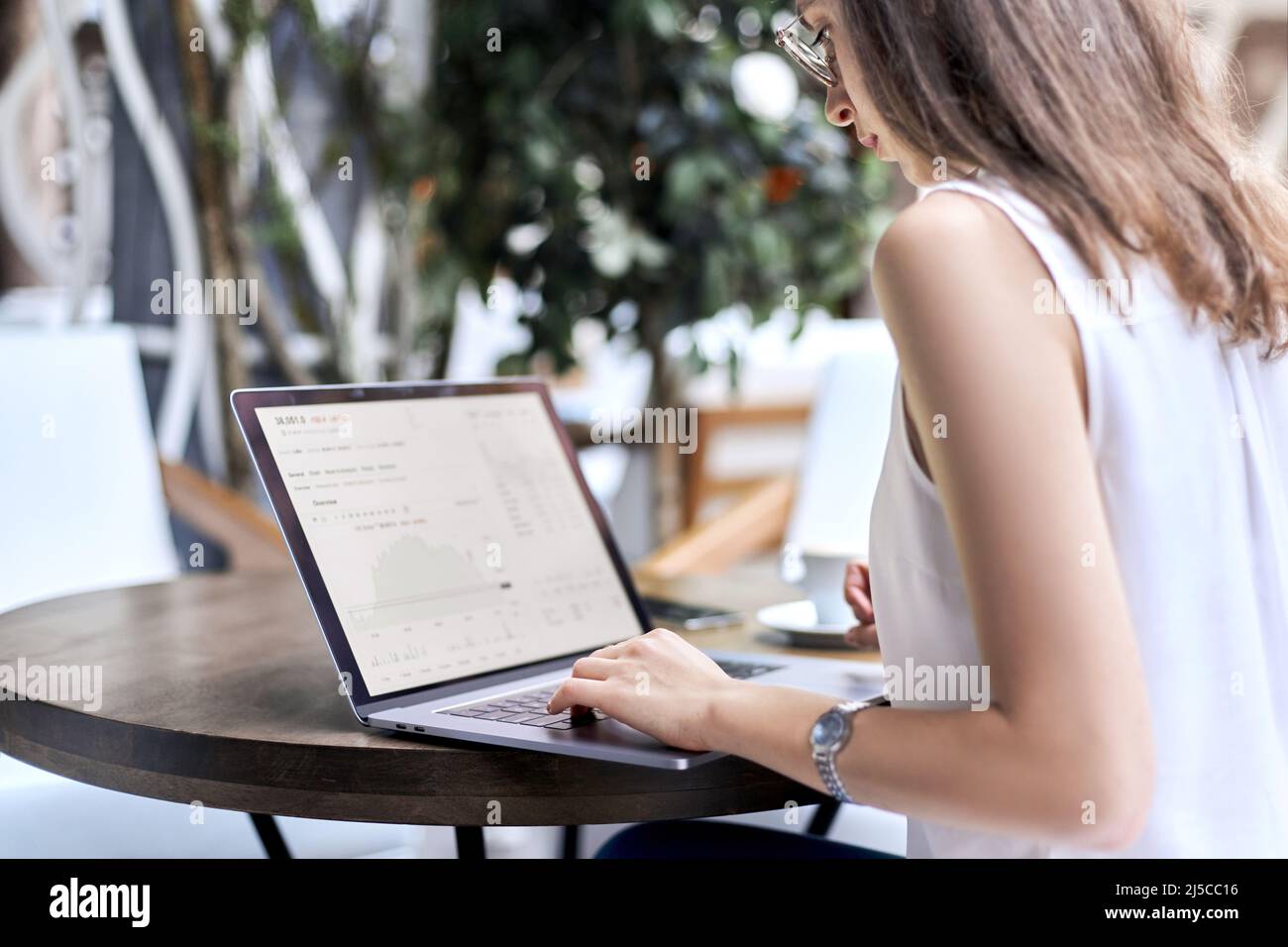 image of a young woman using a laptop to work with documents. Stock Photo