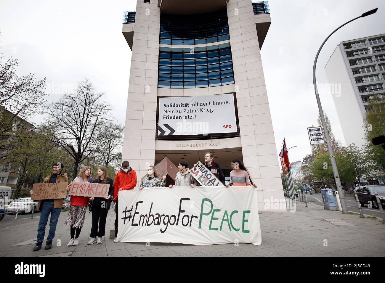 Berlin, Germany. 22nd Apr, 2022. Activists of the organization Fridays for Future from different countries demonstrate with a poster with the inscription '#EmbargoForPeace' in front of SPD party headquarters. On the building hangs an SPD poster with the inscription 'Solidarity with Ukraine. No to Putin's war. Peace now!' Credit: Carsten Koall/dpa/Alamy Live News Stock Photo