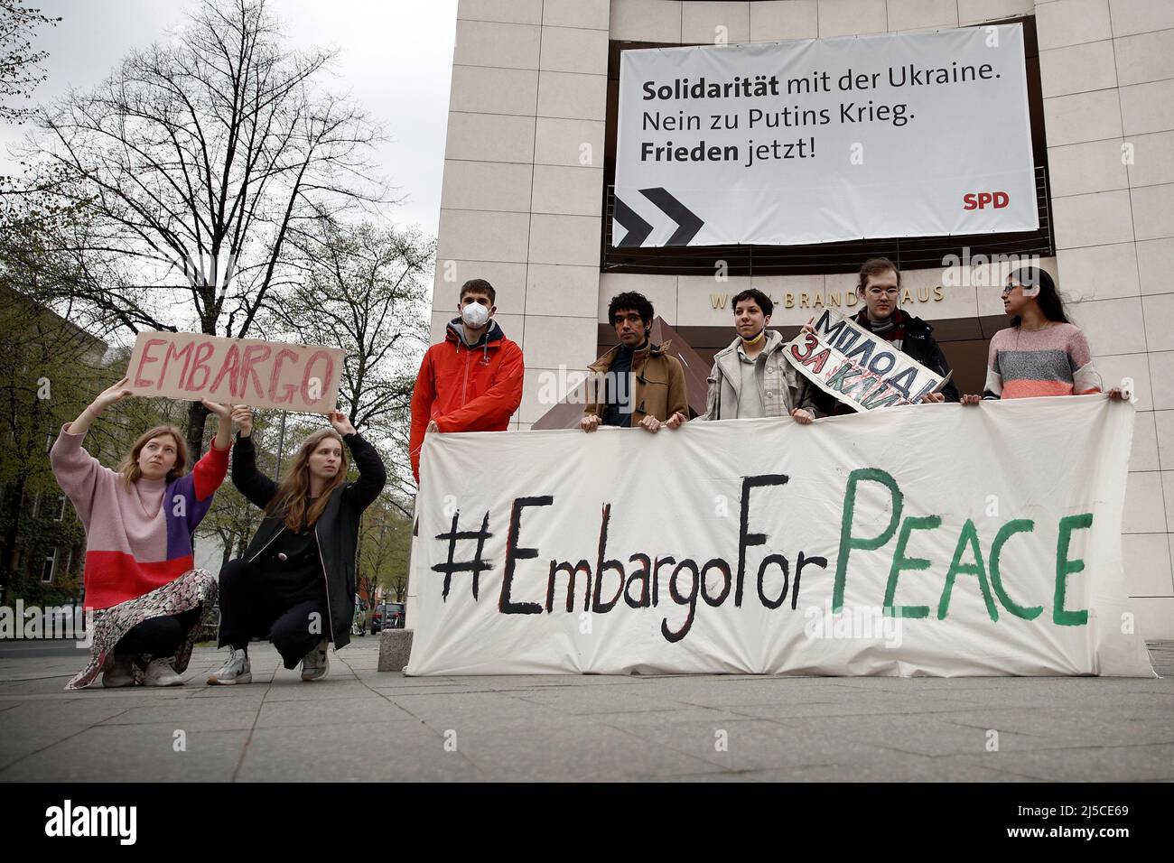 Berlin, Germany. 22nd Apr, 2022. Activists of the organization Fridays for Future from different countries demonstrate with a poster with the inscription '#EmbargoForPeace' in front of SPD party headquarters. On the building hangs an SPD poster with the inscription 'Solidarity with Ukraine. No to Putin's war. Peace now!' Credit: Carsten Koall/dpa/Alamy Live News Stock Photo