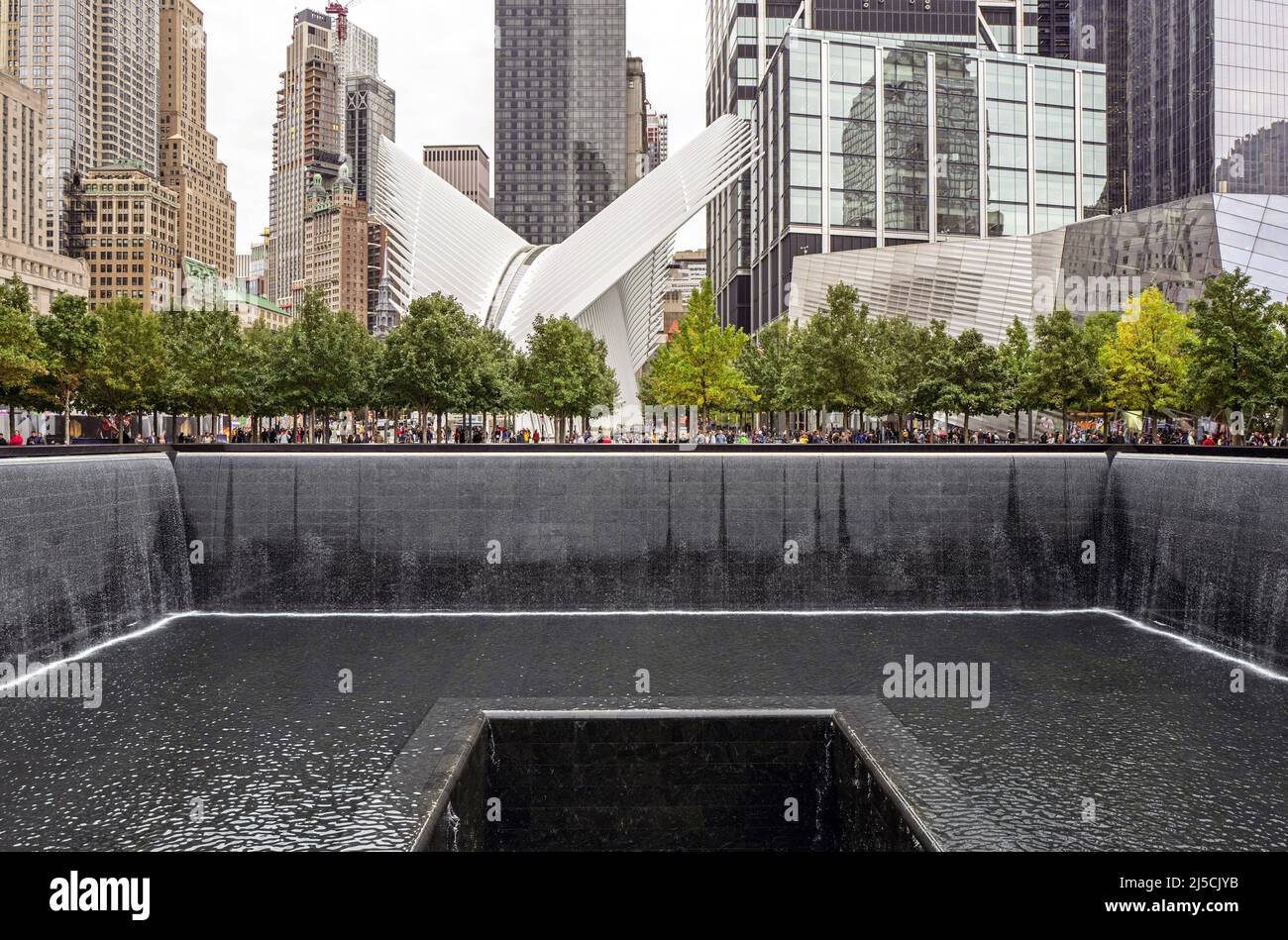 'USA, New York, Oct. 04, 2019. the National 9/11 Memorial in Manhattan on Oct. 08, 2019. the 9/11 Memorial is a memorial commemorating the approximately 3,000 victims of the Sept. 11, 2001 terrorist attacks and the 1993 World Trade Center bombing. In the background: Calatrava's Oculus train station. The World Trade Center transportation hub 'Oculus NYC' designed by Santiago Calatrava is conceived at street level as a freestanding structure located on an axis along the southern edge of the ''Wedge of Light'' plaza. [automated translation]' Stock Photo