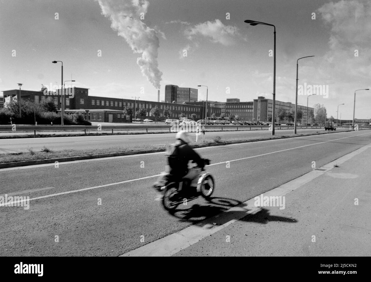 Schkopau, DEU, 09.09.1996 - A moped rider drives past the former VEB Chemische Werke Buna. The Buna plant was one of the five largest industrial combines in the GDR. In 1995, the American corporation Dow Chemical took over large parts of the production facilities. The Schkopau plant has been part of Dow Olefinverbund GmbH since 2004. [automated translation] Stock Photo