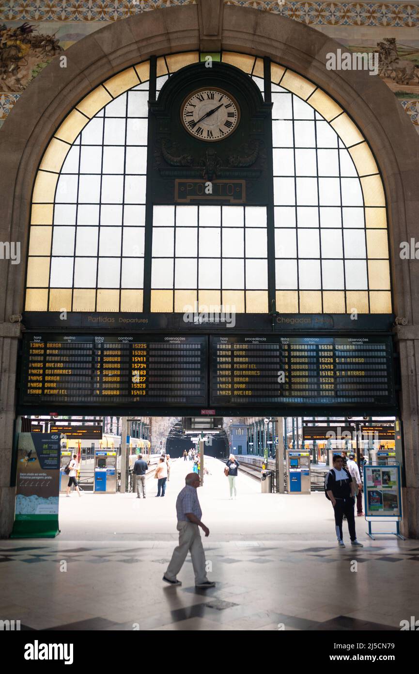 06/15/2018, Porto, Portugal, Europe - Train passengers in the vestibule of Porto's Sao Bento (St. Benedict) train station in the historic center, with station clock and display board. [automated translation] Stock Photo
